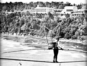 The Great Farini crossing the Niagara Gorge with an Empire Washing Machine strapped to his back, 15 August 1860.