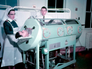 Patient in Iron Lung with Nursing Lt. H.F. Ott and Surgeon Lt. K.R. Flegg, 16 May 1957